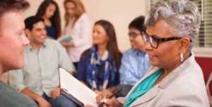 older black woman working with adults in clinic