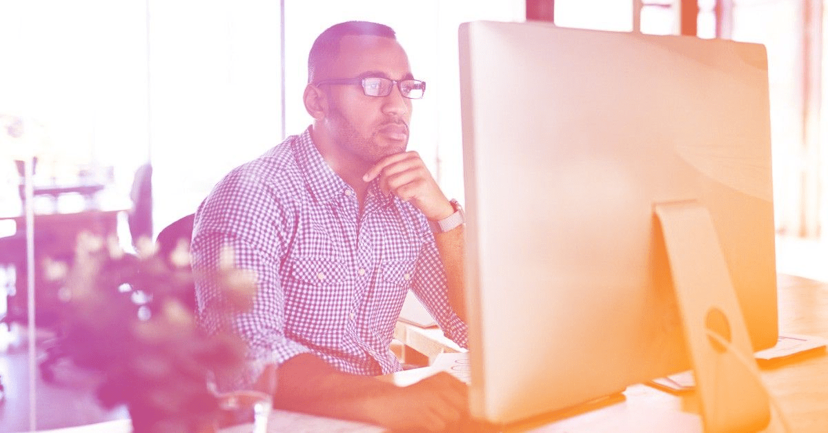 man with glasses looking at computer
