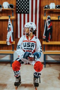 Hannah Luckman in Hockey gear in front of American flag